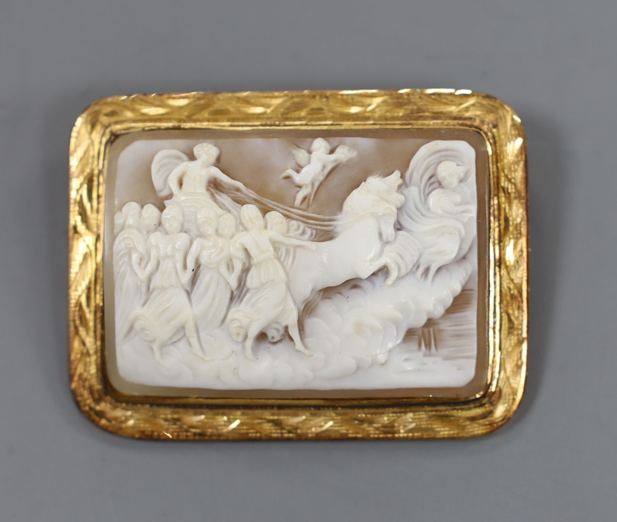 A yellow metal amounted rectangular cameo shell brooch, carved with figures cherubs and chariot, 50mm.